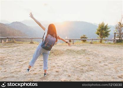 Relaxing in Nature concept from hipster girl with backpack that is smiling, cheerful and happy with atmosphere of autumn sunset on hills.