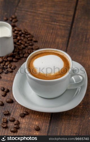 Relaxing latte coffee in white porcelain cup on wooden table