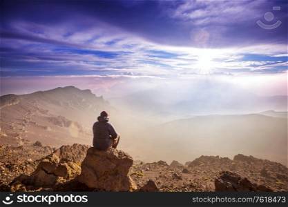 Relaxing man in the mountains at sunrise