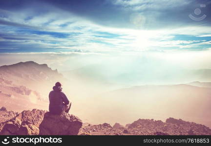 Relaxing man in the mountains at sunrise