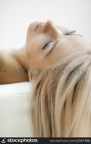 Relaxing. Young girl lying on a sofa, relaxing, natural light from window