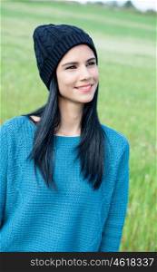 Relaxing young woman with wool cap outside