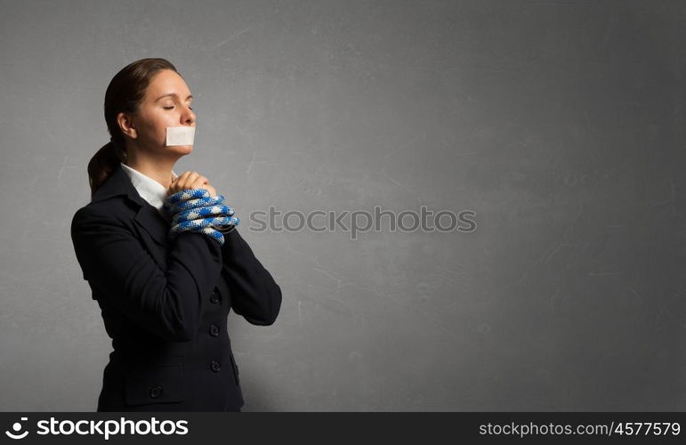 Release of guiltless accused. Young businesswoman with tape on mouth and tired hands