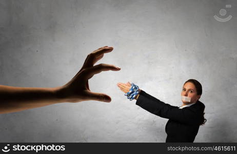 Release of guiltless accused. Young businesswoman with tape on mouth and tired hands