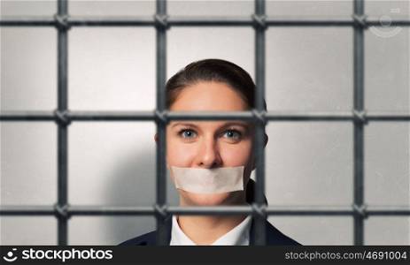 Release of guiltless accused. Young businesswoman with tape on mouth and tired hands