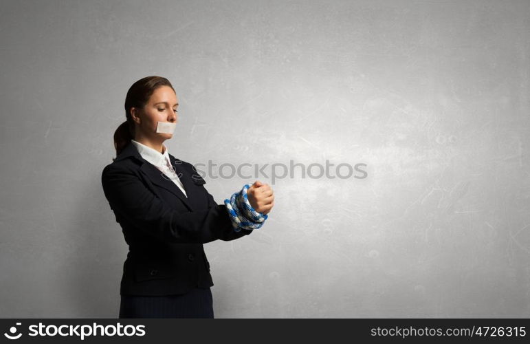 Release of guiltless accused. Young businesswoman with tape on mouth and tired hands