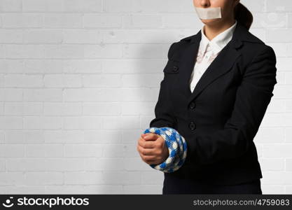 Release of guiltless accused. Young businesswoman with tape on mouth and tired hands