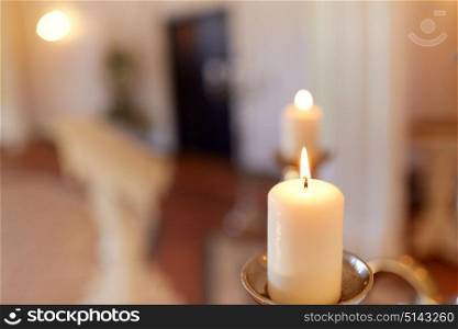 religion and christianity concept - candles burning in church. candles burning in church
