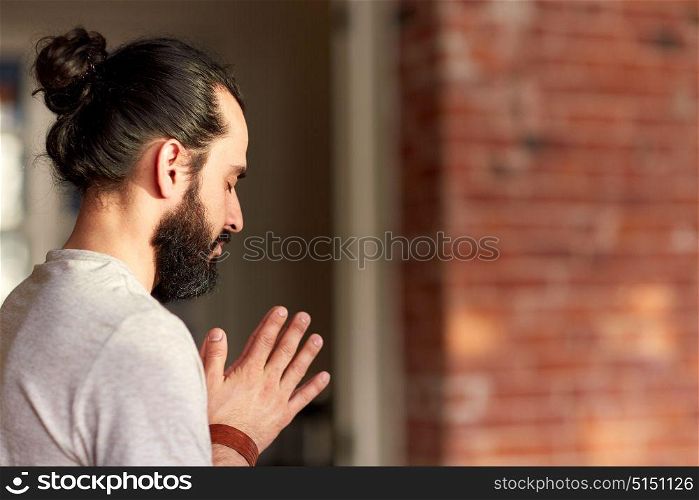 religion, faith and people concept - close up of man meditating at yoga studio. close up of man meditating at yoga studio