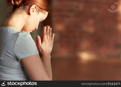 religion, faith and people concept - close up of woman meditating at yoga studio. close up of woman meditating at yoga studio