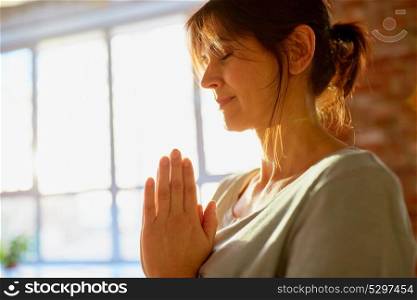 religion, faith, harmony and people concept - close up of yogi woman meditating at yoga studio. close up of yogi woman meditating at yoga studio