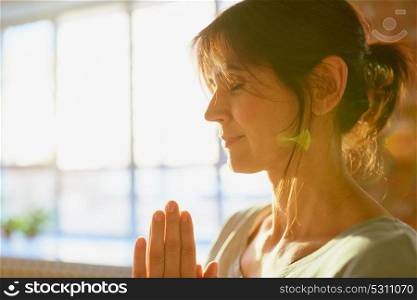 religion, faith, harmony and people concept - close up of yogi woman meditating at yoga studio. close up of yogi woman meditating at yoga studio