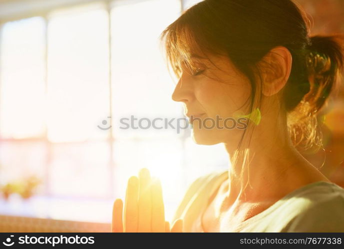 religion, faith, harmony and people concept - close up of yogi woman meditating at yoga studio. close up of yogi woman meditating at yoga studio