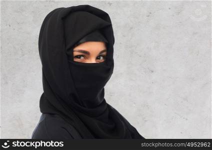 religious and people concept - close up of muslim woman in hijab over gray concrete wall background. close up of muslim woman in hijab