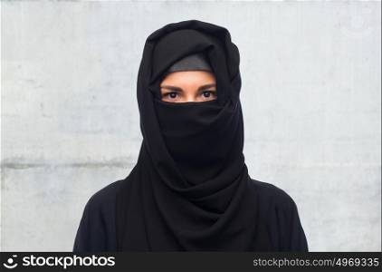 religious and people concept - muslim woman in hijab over gray concrete wall background. muslim woman in hijab over gray background