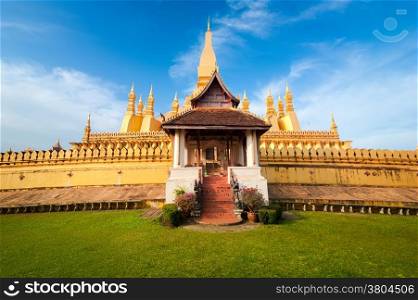 Religious architecture and landmarks. Golden buddhist pagoda of Phra That Luang Temple under blue sky. Vientiane, Laos travel landscape and destinations