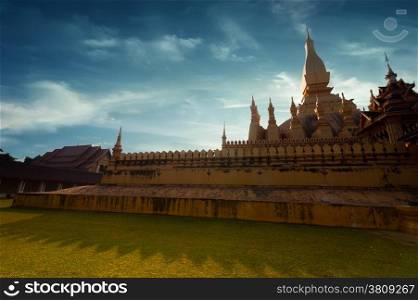 Religious architecture and landmarks. Golden buddhist pagoda of Phra That Luang Temple under sunset sky. Vientiane, Laos travel landscape and destinations