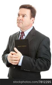 Religious Christian man in a business suit, holding his bible and looking heavenward. Isolated on white.