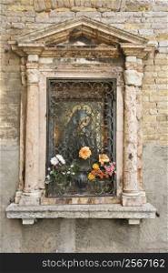 Religious shrine on exterior of building in Venice, Italy.