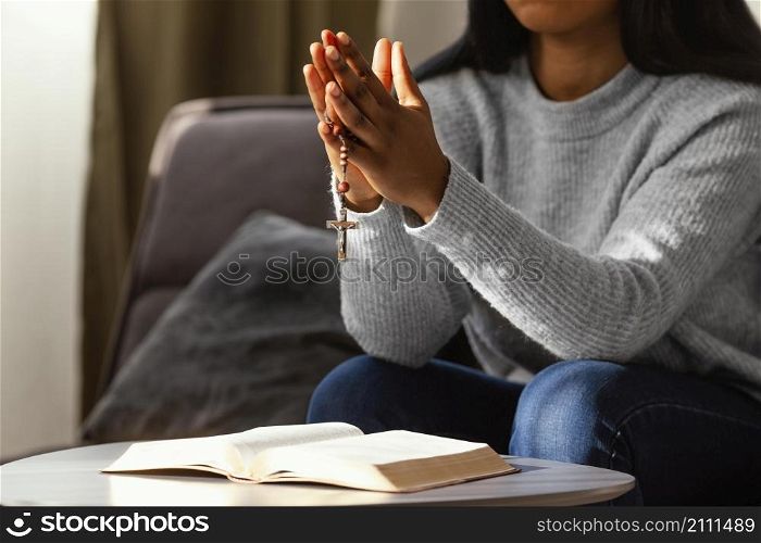 religious woman praying with rosary beads