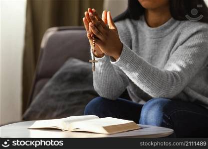 religious woman praying with rosary beads