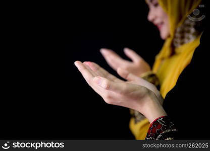 religious young Muslim two women praying over black background.