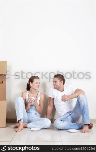 Relocated couple drinking tea on the floor