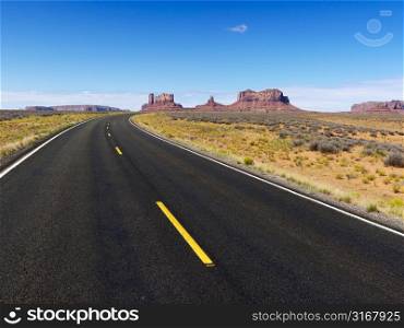 Remote desert road with mountain land formations.