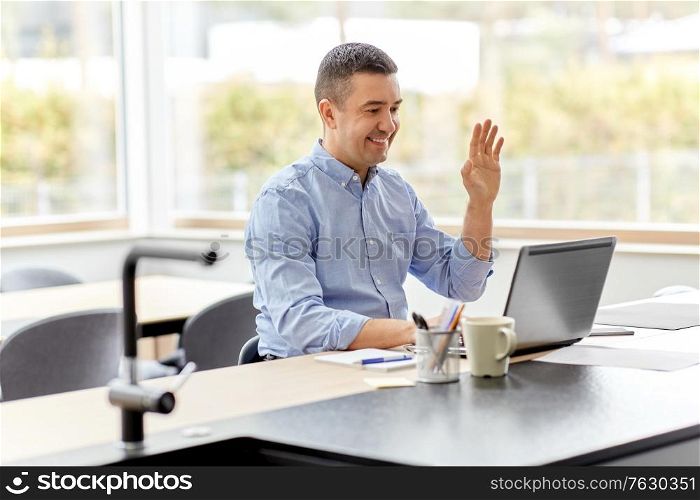 remote job, business and people concept - happy smiling middle-aged man with laptop computer working at home office and having video call. man with laptop having video call at home office