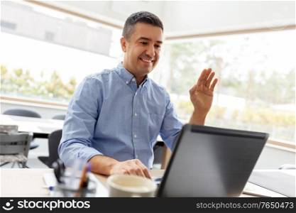remote job, business and people concept - happy smiling middle-aged man with laptop computer working at home office and having video call. man with laptop having video call at home office