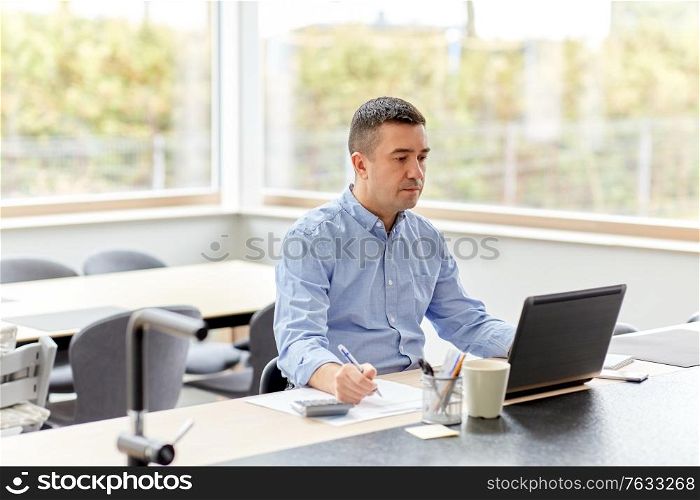 remote job, business and people concept - middle-aged man with calculator, papers and laptop computer working at home office. man with calculator and papers working at home