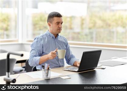 remote job, business and people concept - middle-aged man with laptop computer working at home office and drinking coffee. man with laptop drinking coffee at home office
