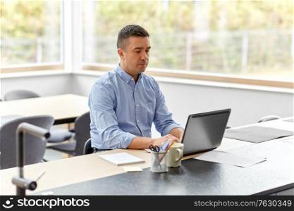 remote job, business and people concept - middle-aged man with laptop computer working at home office. man with laptop working at home office