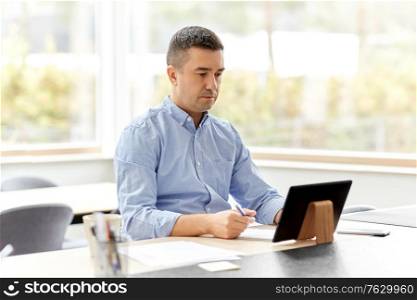 remote job, business and people concept - middle-aged man with tablet pc computer working at home office. man with tablet computer working at home office