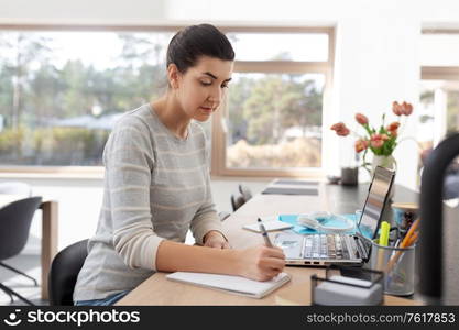 remote job, business and people concept - young woman with laptop computer and notebook working at home office. young woman with laptop working at home office