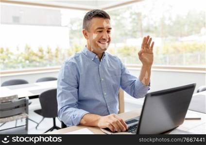 remote job, business and skin health concept - happy smiling middle-aged man with vitiligo on his face working at home office and having video call on laptop computer. man with vitiligo laptop having video call at home