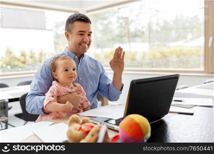 remote job, multi-tasking and family concept - happy smiling middle-aged father with baby working on laptop at home office. father with baby working on laptop at home office