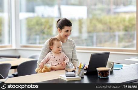remote job, multi-tasking and family concept - happy smiling mother with baby and laptop working at home office. mother with baby and laptop working at home office