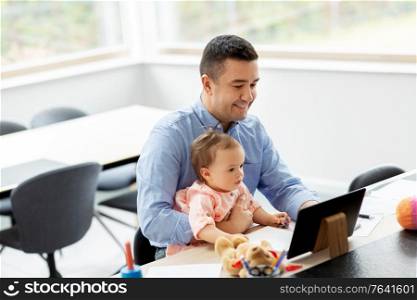 remote job, multi-tasking and family concept - middle-aged father with baby and tablet computer working at home office. father with baby working on tablet pc at home