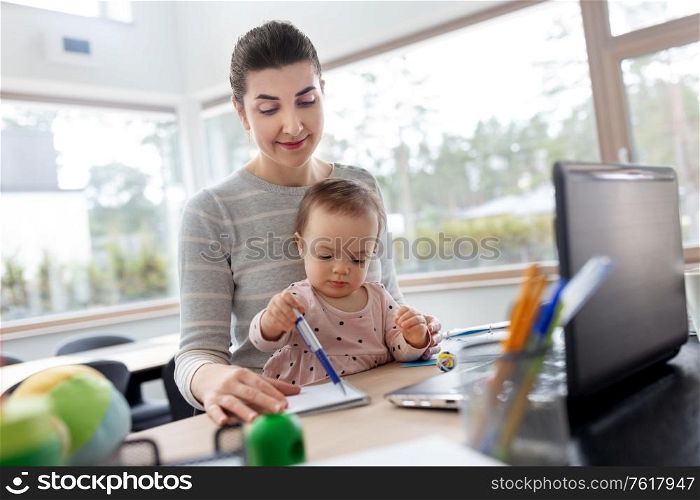 remote job, multi-tasking and family concept - mother with baby working at home office. mother with baby working at home office