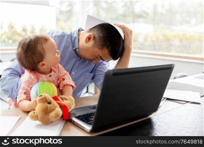 remote job, multi-tasking and family concept - stressed middle-aged father with baby daughter, laptop and papers working at home office. father with baby working on laptop at home office