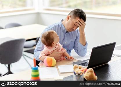 remote job, multi-tasking and family concept - tired middle-aged father with baby working on laptop at home office. father with baby working on laptop at home office