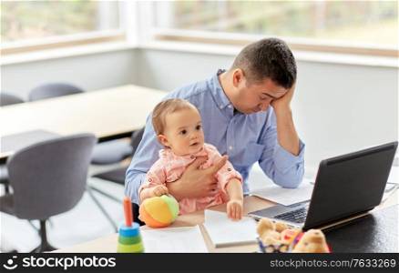 remote job, multi-tasking and family concept - tired middle-aged father with baby working on laptop at home office. father with baby working on laptop at home office