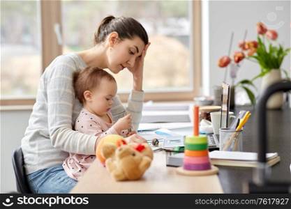 remote job, multi-tasking and family concept - tired mother with baby working at home office. tired mother with baby working at home office