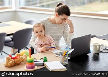 remote job, multi-tasking and family concept - tired mother with baby working at home office. tired mother with baby working at home office
