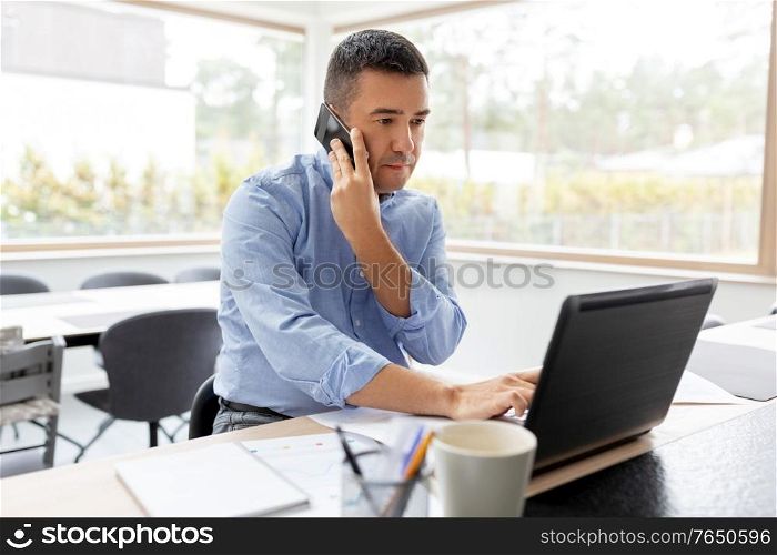 remote job, technology and business concept - middle-aged man with laptop computer calling on smartphone at home office. man calling on smartphone at home office