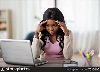 remote job, technology and people concept - african american tired or stressed young woman with laptop computer working at home office. stressed woman with laptop working at home office