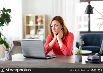 remote job, technology and people concept - bored or tired young woman with laptop computer working at home office. bored woman with laptop working at home office