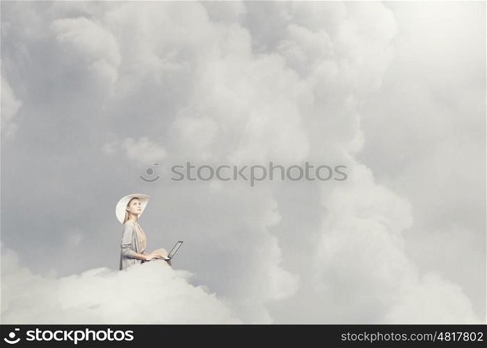 Remote work. Woman in dress and hat sitting on cloud and working on laptop