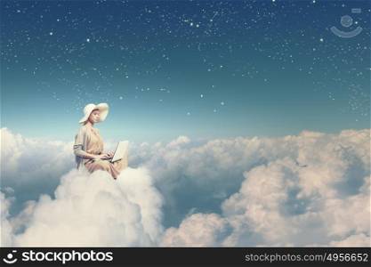 Remote work. Woman in dress and hat sitting on cloud and working on laptop